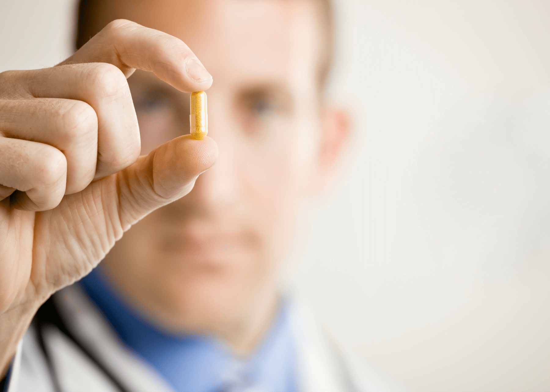 doctor holding yellow pill